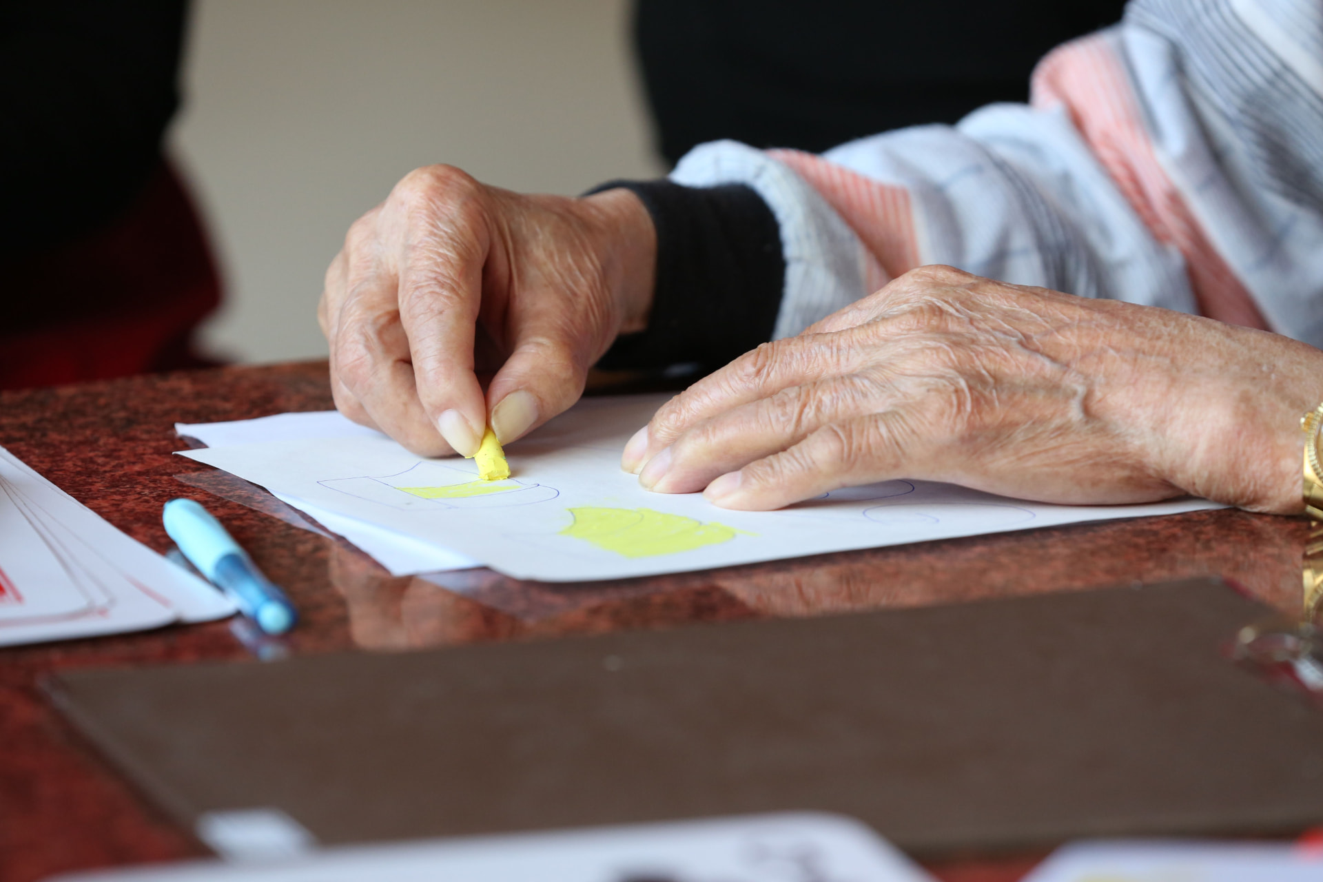 Older adult completing a therapy worksheet during a home visit